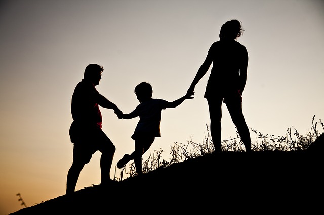 Familie auf Wiesenhügel in der Dämmerung